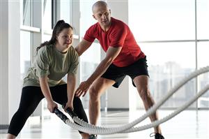 Man and woman working with battle ropes